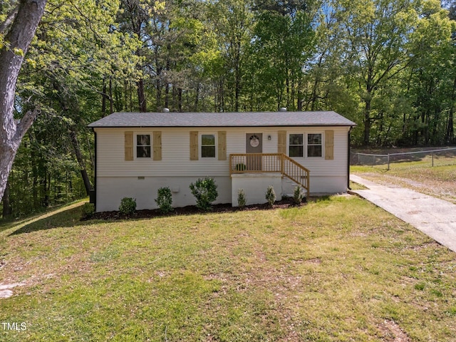 view of front facade with fence, crawl space, and a front yard