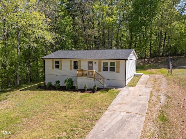 view of front of property featuring crawl space, roof with shingles, driveway, and a front yard
