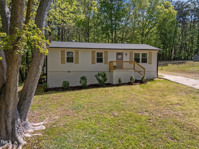 ranch-style home featuring a front lawn, fence, driveway, and crawl space