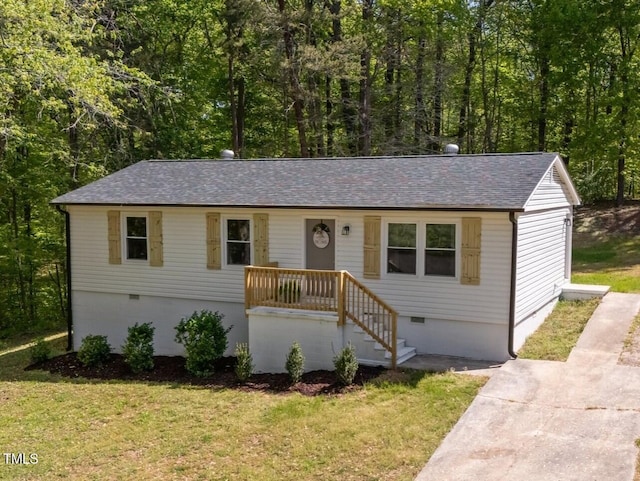 ranch-style home featuring roof with shingles, crawl space, and a front yard
