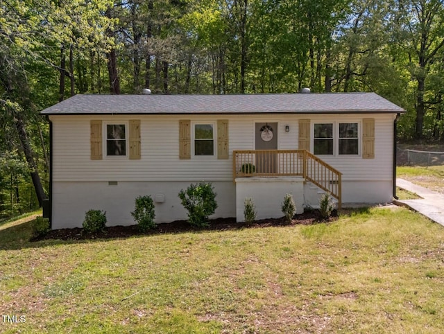 ranch-style house with a shingled roof and a front lawn
