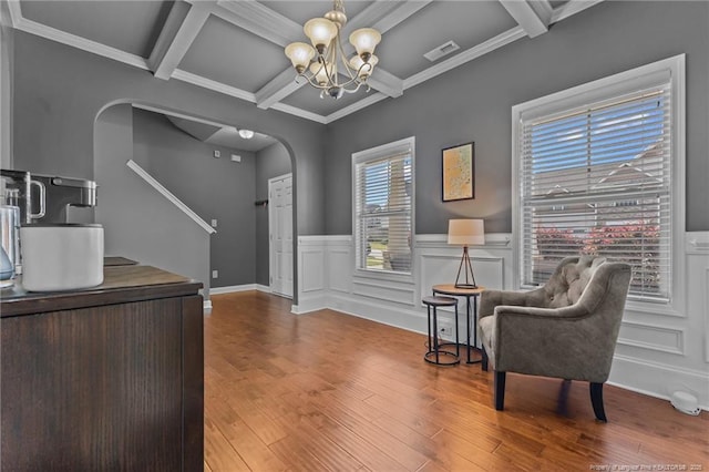 sitting room with beamed ceiling, arched walkways, visible vents, coffered ceiling, and a notable chandelier