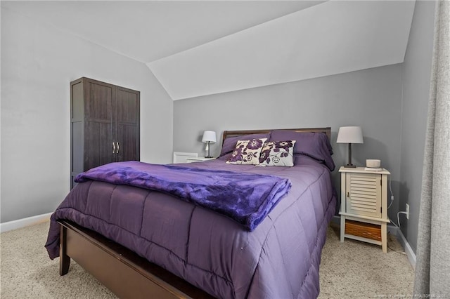 carpeted bedroom featuring baseboards and vaulted ceiling