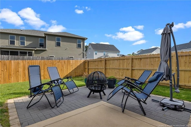 view of patio / terrace with an outdoor fire pit, a fenced backyard, and a residential view