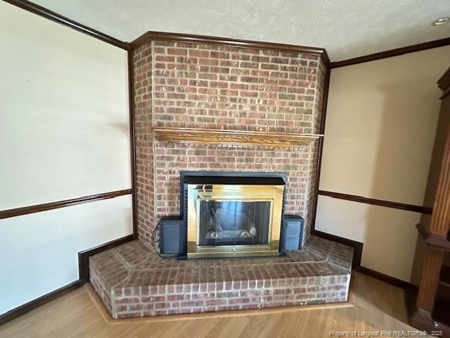 5423 Fisher Rd, Fayetteville, NC 28304 - interior details featuring ornamental molding, baseboards, wood finished floors, and a fireplace