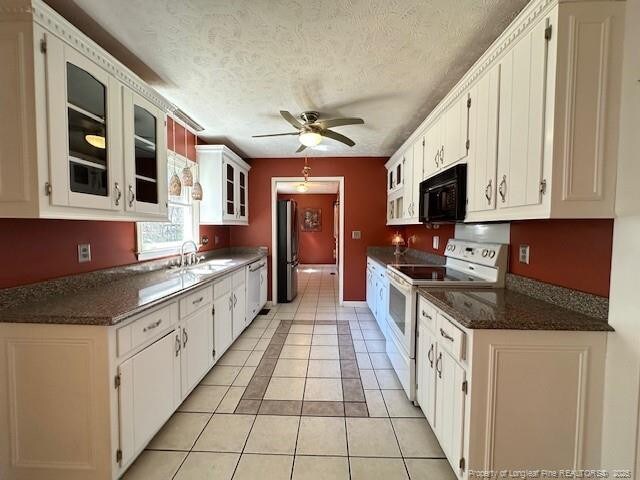 5423 Fisher Rd, Fayetteville, NC 28304 - kitchen featuring white appliances, a ceiling fan, white cabinetry, a sink, and dark countertops