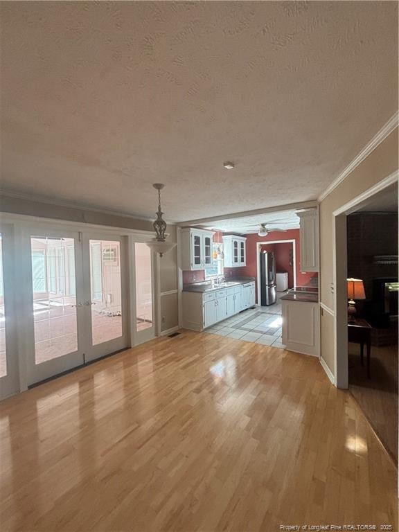 5423 Fisher Rd, Fayetteville, NC 28304 - interior space with french doors, light wood-type flooring, crown molding, and a textured ceiling