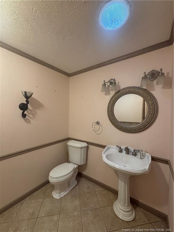 5423 Fisher Rd, Fayetteville, NC 28304 - bathroom with toilet, baseboards, ornamental molding, and tile patterned flooring