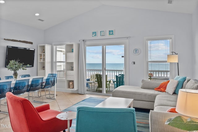 living area featuring a water view, lofted ceiling, and a wealth of natural light