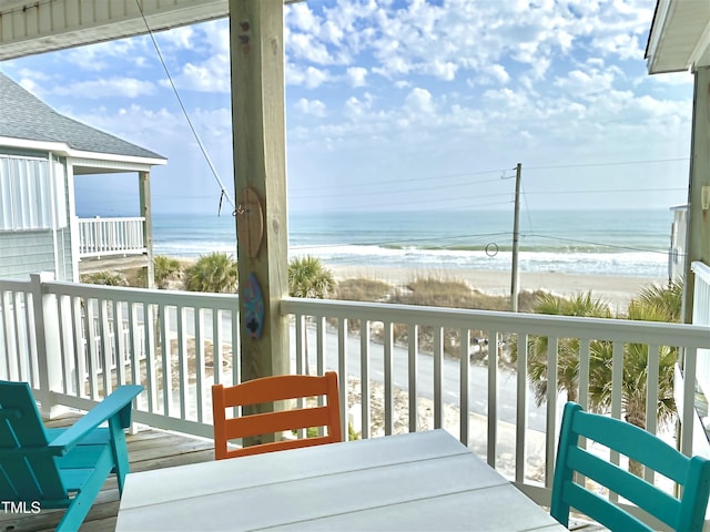 balcony featuring a water view and a beach view