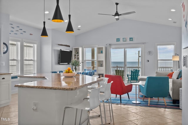 kitchen with open floor plan, a healthy amount of sunlight, white cabinetry, and light stone countertops