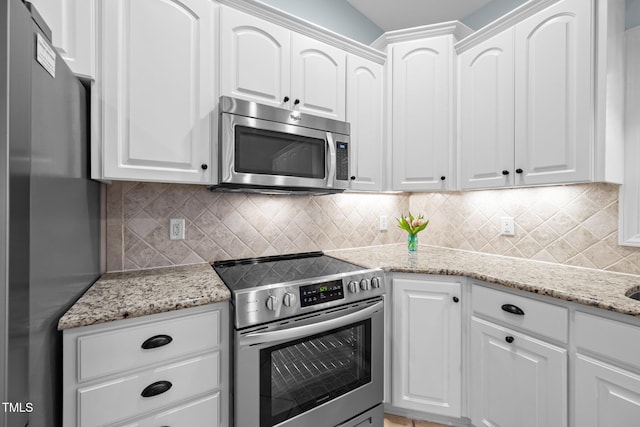 kitchen featuring tasteful backsplash, light stone counters, white cabinetry, and stainless steel appliances