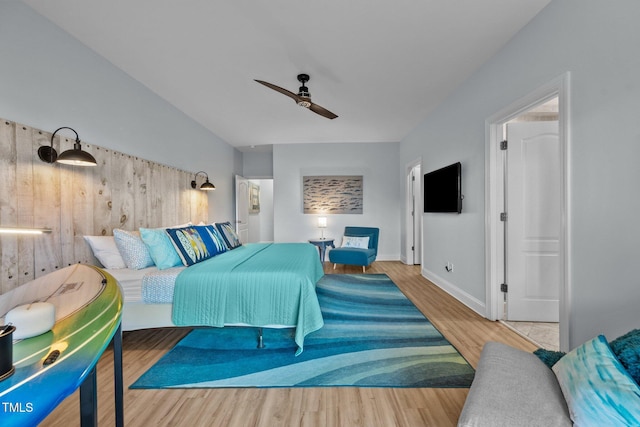 bedroom with wood finished floors, baseboards, a ceiling fan, and vaulted ceiling