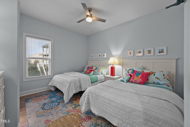 bedroom with visible vents, baseboards, a ceiling fan, and wood finished floors