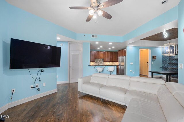 living room featuring a ceiling fan, visible vents, dark wood finished floors, baseboards, and recessed lighting