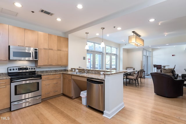 kitchen featuring open floor plan, appliances with stainless steel finishes, light wood-style flooring, and visible vents