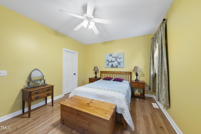 bedroom featuring light wood finished floors, baseboards, and ceiling fan