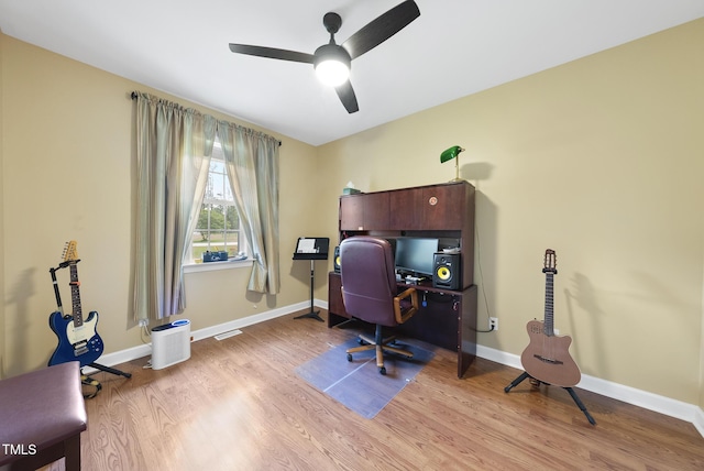 home office with a ceiling fan, light wood-style flooring, and baseboards