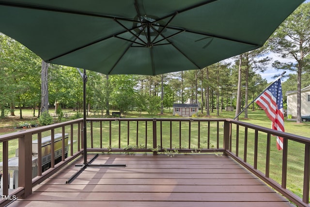 wooden terrace with an outdoor structure and a lawn