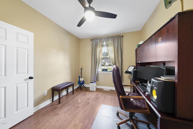 office area featuring a ceiling fan, light wood finished floors, and baseboards