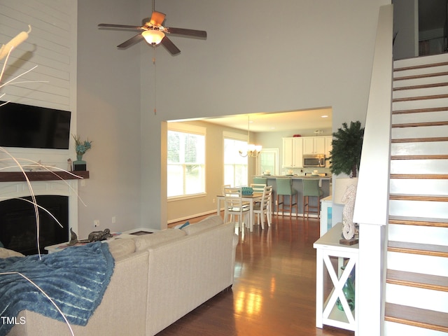 3530 Winding Walk Ct, Raleigh, NC 27616 - living area featuring a towering ceiling, stairway, dark wood-style floors, a fireplace, and a ceiling fan