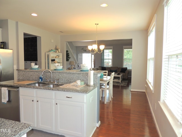 3530 Winding Walk Ct, Raleigh, NC 27616 - kitchen with stainless steel dishwasher, a sink, open floor plan, white cabinets, and light stone countertops