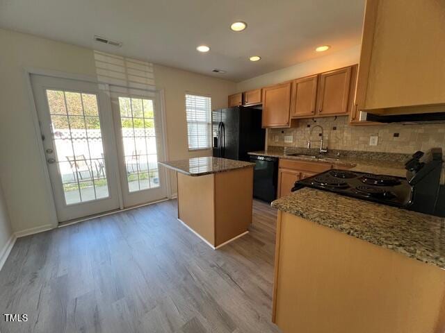 8013 River Water Ct, Raleigh, NC 27616 - kitchen featuring a kitchen island, black appliances, light wood-style floors, decorative backsplash, and a sink