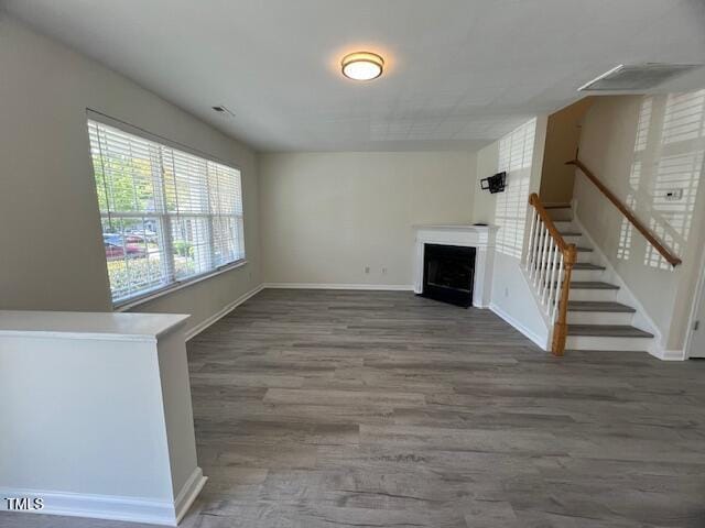 8013 River Water Ct, Raleigh, NC 27616 - unfurnished living room featuring baseboards, stairway, wood finished floors, and a fireplace