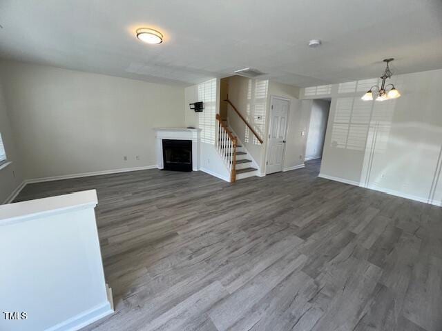 8013 River Water Ct, Raleigh, NC 27616 - unfurnished living room featuring baseboards, a chandelier, wood finished floors, and a fireplace