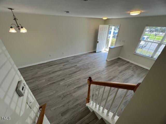 8013 River Water Ct, Raleigh, NC 27616 - stairway with a chandelier, wood finished floors, and baseboards