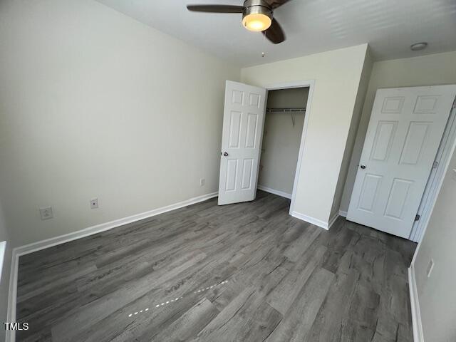 8013 River Water Ct, Raleigh, NC 27616 - unfurnished bedroom with dark wood-type flooring, a closet, baseboards, and a ceiling fan