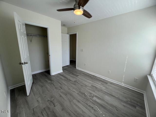 8013 River Water Ct, Raleigh, NC 27616 - unfurnished bedroom with dark wood-type flooring, a closet, baseboards, and ceiling fan