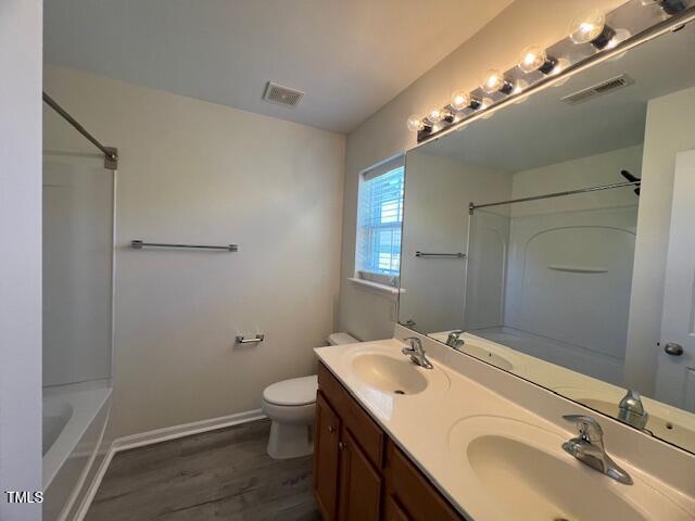 8013 River Water Ct, Raleigh, NC 27616 - full bath with visible vents, a sink, and wood finished floors