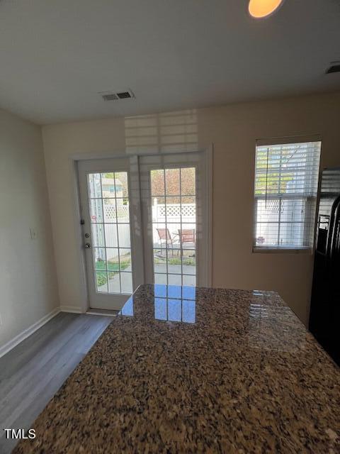 8013 River Water Ct, Raleigh, NC 27616 - interior space featuring stone countertops, baseboards, black fridge, visible vents, and wood finished floors