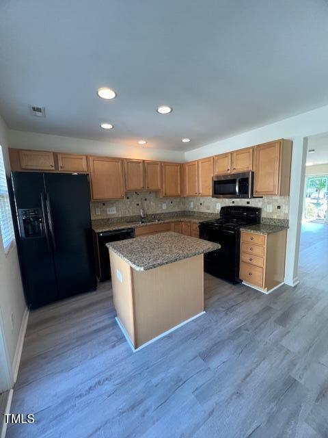 8013 River Water Ct, Raleigh, NC 27616 - kitchen featuring black appliances, light stone countertops, visible vents, decorative backsplash, and a sink