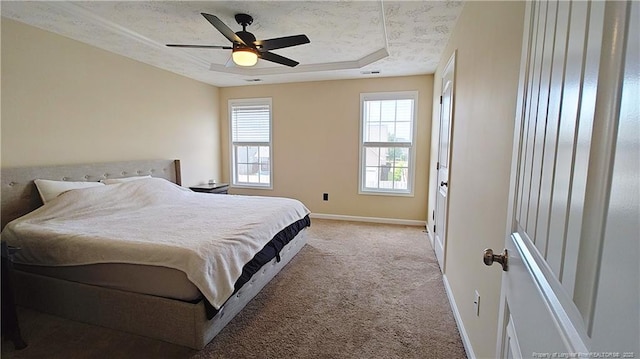 bedroom with light colored carpet, a ceiling fan, and baseboards