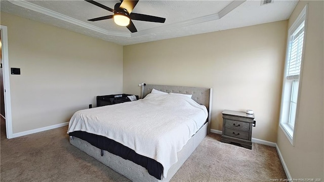 bedroom featuring carpet flooring, multiple windows, and a raised ceiling