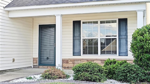 1221 Piping Plover Ct, Fayetteville, NC 28306 - entrance to property with covered porch, stone siding, and roof with shingles