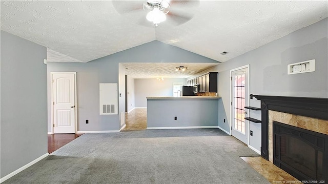 1221 Piping Plover Ct, Fayetteville, NC 28306 - unfurnished living room featuring ceiling fan, lofted ceiling, a textured ceiling, carpet floors, and a fireplace