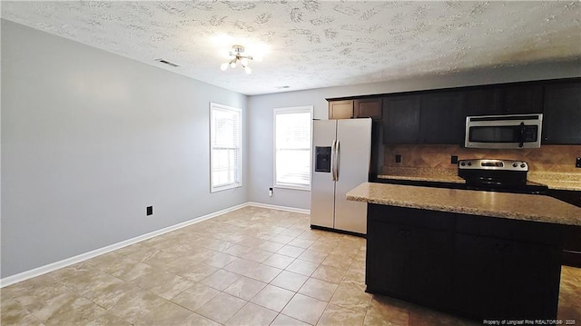 1221 Piping Plover Ct, Fayetteville, NC 28306 - kitchen featuring stainless steel appliances, tasteful backsplash, light stone countertops, a textured ceiling, and baseboards