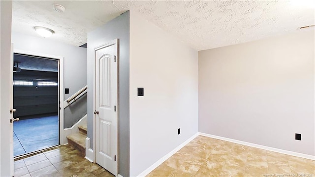 1221 Piping Plover Ct, Fayetteville, NC 28306 - corridor with a textured ceiling, stairs, tile patterned floors, and baseboards