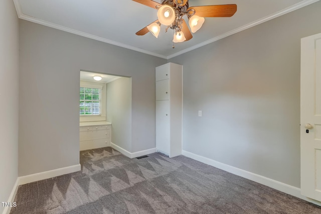 carpeted empty room featuring crown molding, ceiling fan, and baseboards