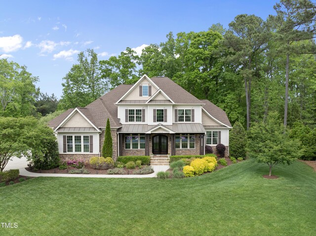 craftsman-style house featuring stone siding, a standing seam roof, metal roof, and a front yard