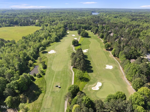 drone / aerial view with view of golf course and a forest view