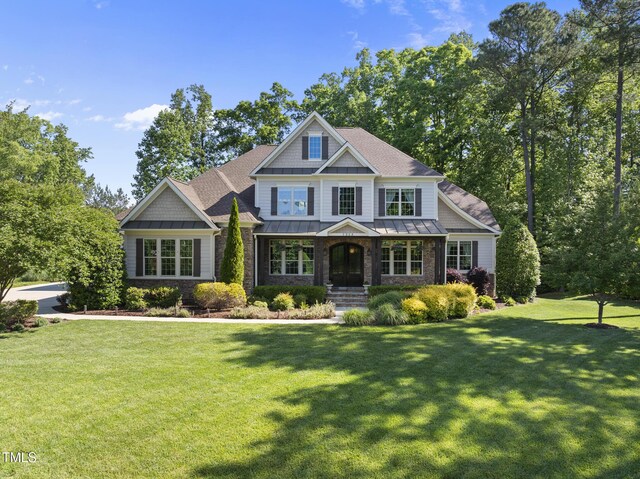 craftsman house with roof with shingles, a porch, a front yard, a standing seam roof, and metal roof