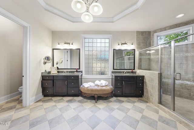 full bathroom featuring ornamental molding, two vanities, a chandelier, and a shower stall