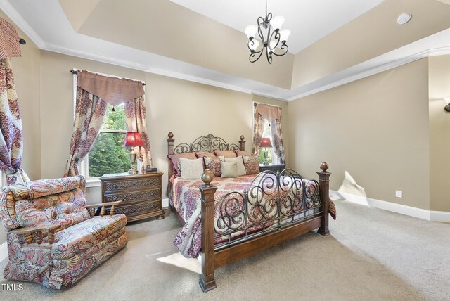 carpeted bedroom with an inviting chandelier, baseboards, and a tray ceiling