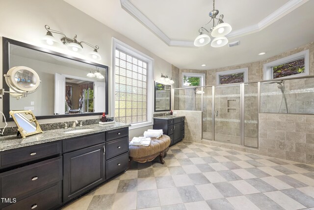 bathroom featuring a sink, a notable chandelier, a wealth of natural light, and a shower stall