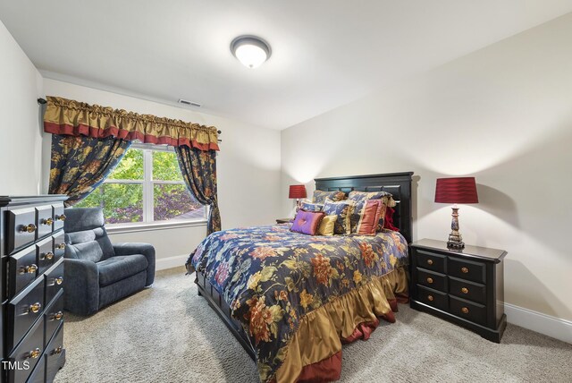 carpeted bedroom featuring baseboards and visible vents