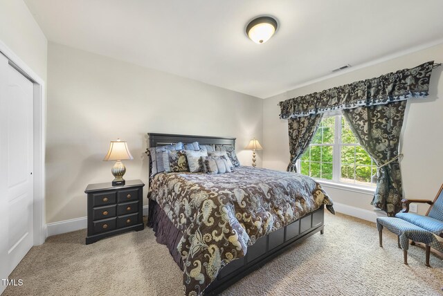 carpeted bedroom featuring baseboards and visible vents